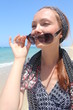 Foto: Red hair woman holding her sunglasses, at the beach Red hair woman holding her sunglasses, at the beach