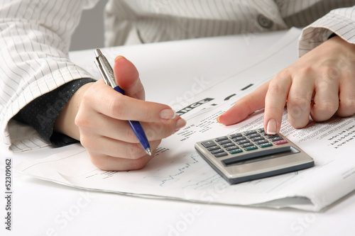 Photo: Business woman working with tax documents Business woman working with tax documents
