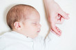 cute one month old baby holding finger of his mothers