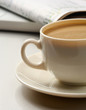 cup near newspapers