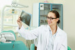 Dentist doctor smiling and holding x-ray