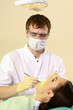 Young woman with dentist in a dental surgery.