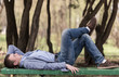 Foto: Young the man lays on a bench Young the man lays on a bench