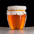Glass jar with honey isolated on black background