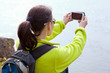 Woman hiker taking a photo  by smartphone
