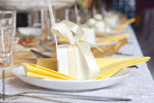 Photo: Wedding table cutlery and gift box on plate background concept Wedding table cutlery and gift box on plate background concept