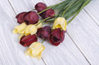 Bouquet of yellow and red tulips on a wooden table