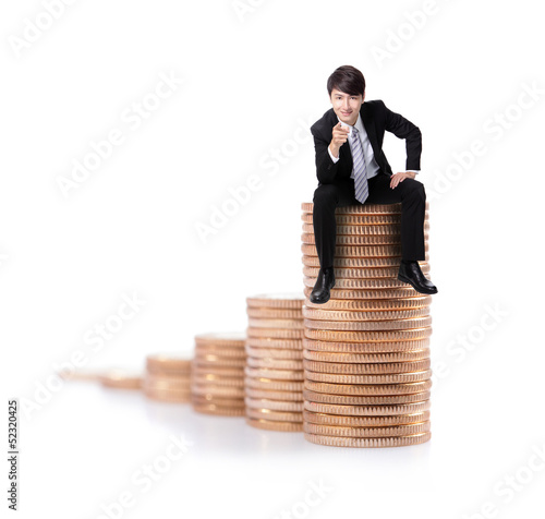 Photo: Successful business man sitting on money stairs Successful business man sitting on money stairs