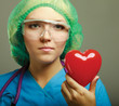 Female doctor with stethoscope holding heart