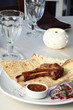 Juicy meat on the bone with onions, served with sauce