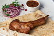 Juicy meat on bone with onions, served with sauce