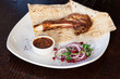 Juicy meat on the bone with onions, served with sauce.
