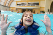 Photo: Happy girl in lifejacket in water park with his hands up. Happy girl in lifejacket in water park with his hands up.