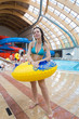 Foto: Woman with swimming toy at the water park. Woman with swimming toy at the water park.