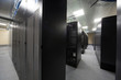 Telecommunication racks in server room with lots of cables.