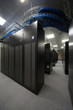 Telecommunication racks in server room with lots of cables.