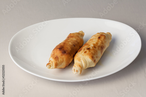 Photo: Appetizing baked with cheese on a plate. Appetizing baked with cheese on a plate.