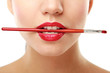 Woman's lips holding make up brush