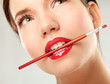 Woman's lips holding make up brush