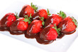 Strawberry dipped in chocolate fondue isolated on white