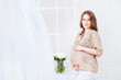 Pregnant woman standing near window