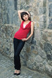 young woman  against old stone wall, outdoor shot