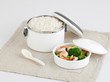 white tiffin carrier with rice and fried shrimps and bloccori