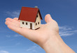 Foto: Hand holding a new house with sky background Hand holding a new house with sky background