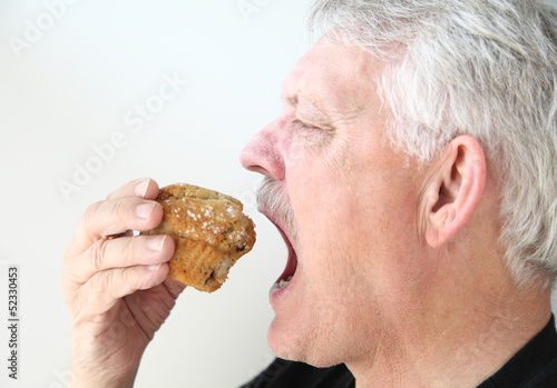 Photo: man eats blueberry muffin man eats blueberry muffin