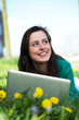 Happy young woman working on laptop outdoors