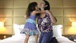 happy mother and daughter playing on bed