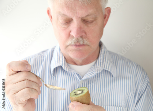 Photo: senior prepares to eat kiwifruit senior prepares to eat kiwifruit