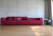 Illustration: Rotes Sofa vor Betonwand Rotes Sofa vor Betonwand