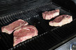 Ribeye steaks cooking on a gas barbecue