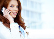 Beautiful business woman talking on cell phone while looking at