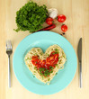 Cooked spaghetti carefully arranged in  heart shape and topped
