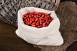 Peanuts in sack on wooden background