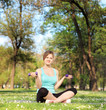 Photo: Young female athlete exercising with dumbbells in park Young female athlete exercising with dumbbells in park