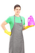 Young man holding a bottle of cleaning liquid