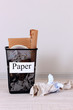 Assorted trash in bucket on room background