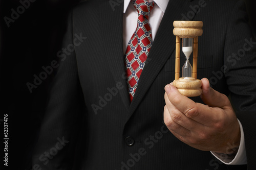 Photo: Businessman holding hourglass Businessman holding hourglass