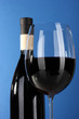 Wine in glass and wine bottle close-up on blue background