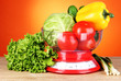 Fresh vegetables in scales on table on orange background