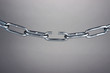 Broken chain on gray background