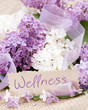 Fliederblüten mit Schild "Wellness"