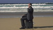 Businessman talking cellphone on beach, super slow motion
