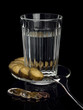 Alcohol in a glass with snack and EURO coins.