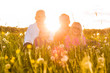 Happy family sitting in summer meadow