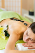 Foto: woman having wellness hot stone massage woman having wellness hot stone massage