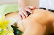 Foto: woman having wellness hot stone massage woman having wellness hot stone massage